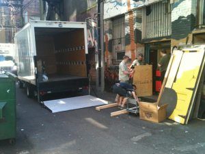 In this scene our heros are building a staircase to lower the 400kg laser to the pavement. In the distance the regular delivery has to back his truck out of the alley.